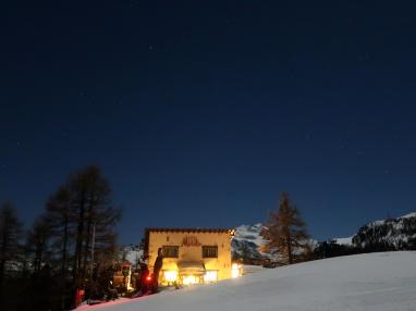Kleines warmes Restaurant Moosalp vor der Mischabelgruppe in kühler Nacht.